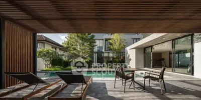 Luxurious modern home with poolside patio and sleek outdoor furniture.