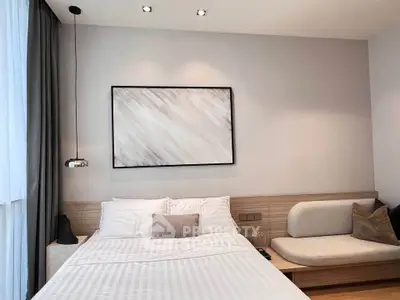 Modern bedroom with stylish decor and cozy seating area, perfect for relaxation.