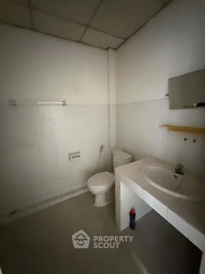Simple bathroom with white tiles and basic fixtures