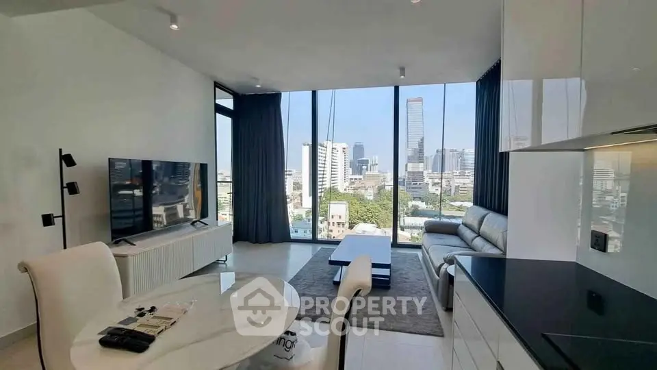 Modern living room with panoramic city view, sleek furniture, and open layout in high-rise apartment.