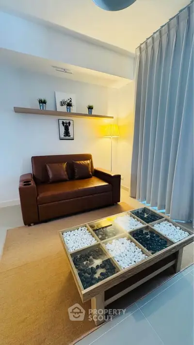 Stylish living room with leather sofa, modern decor, and unique stone coffee table.