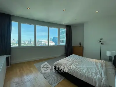Spacious bedroom with panoramic city view and modern decor