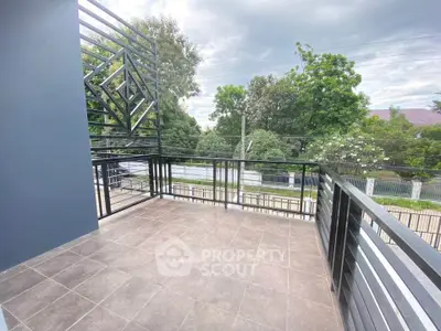 Spacious balcony with modern railing and scenic view of lush greenery.