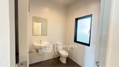 Modern minimalist bathroom with sleek fixtures and frosted window for privacy.