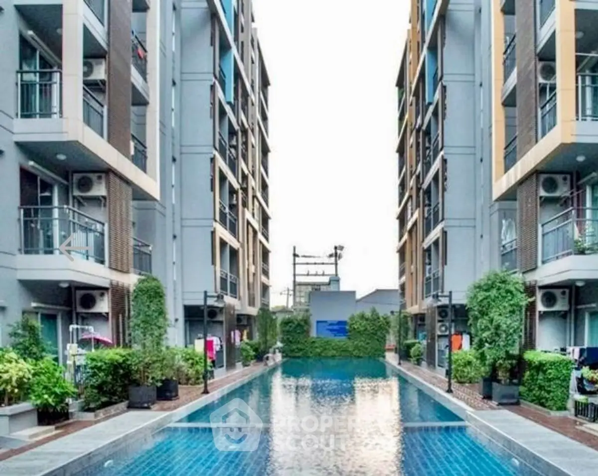 Modern apartment complex with a stunning outdoor pool and lush greenery.