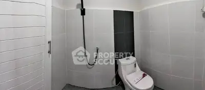 Modern minimalist bathroom with sleek tiles and contemporary fixtures.