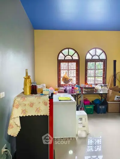 Charming room with arched windows and vibrant decor, perfect for creative living space.
