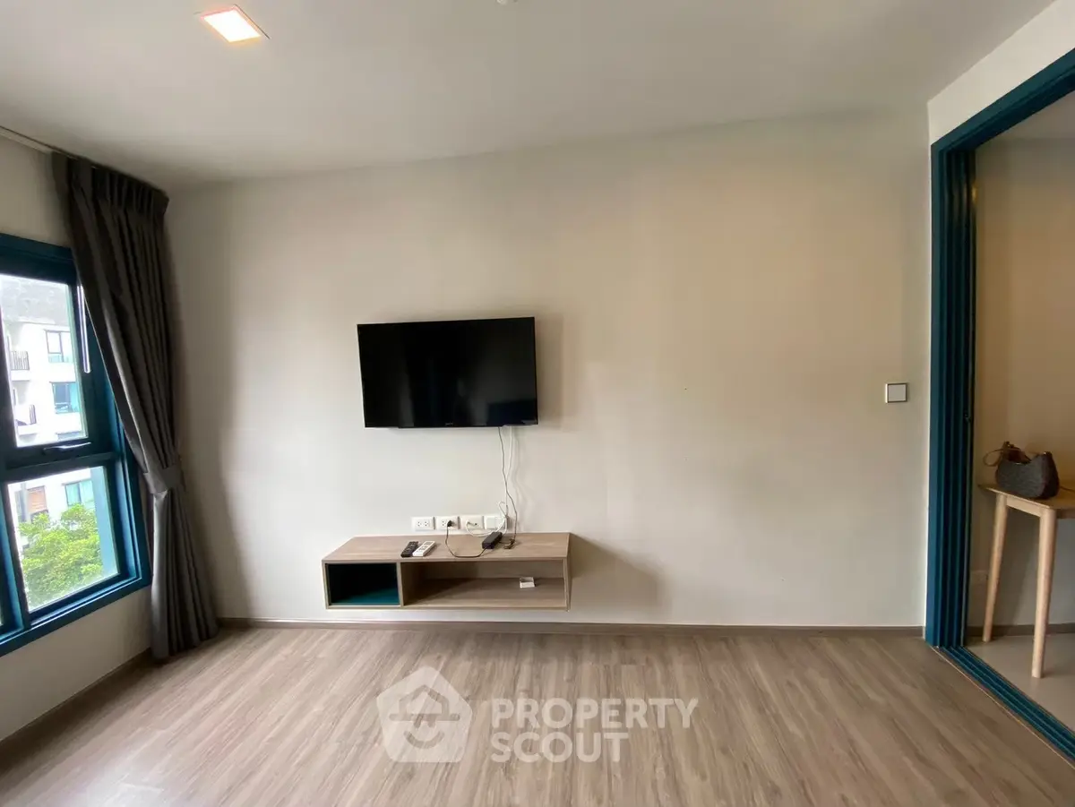 Modern living room with wall-mounted TV and large windows