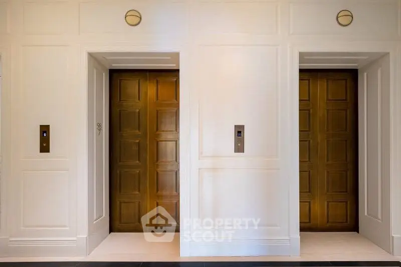 Elegant dual elevator entrance with wooden doors in luxury building