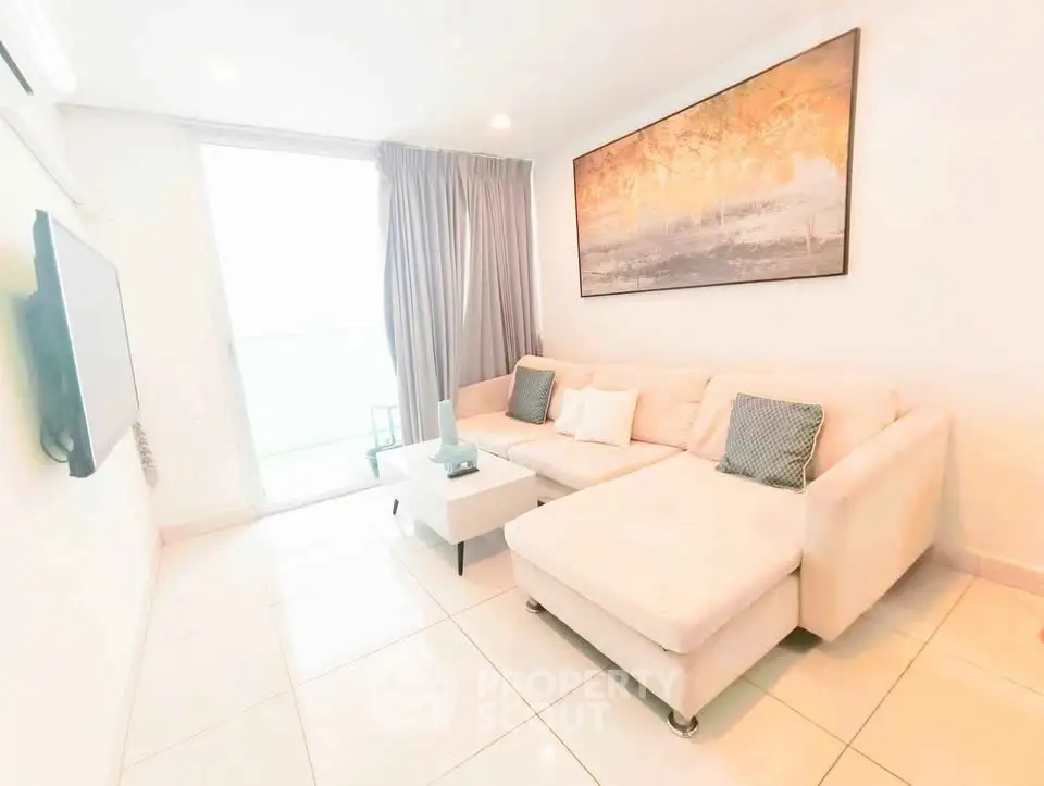 Bright and modern living room with large sofa and wall art, perfect for relaxation.