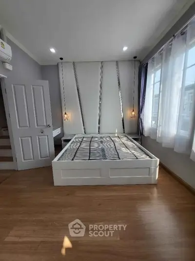 Spacious bedroom with modern design and large windows for natural light.