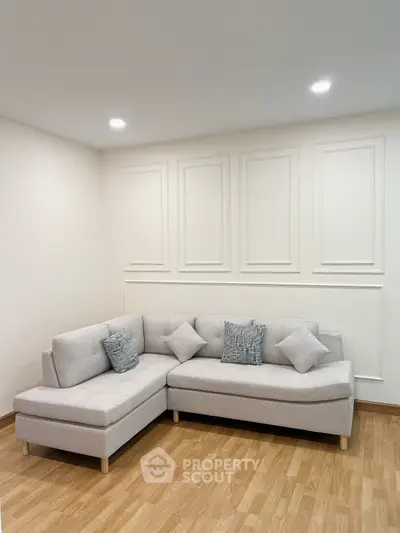 Modern living room with stylish L-shaped sofa and elegant wall paneling