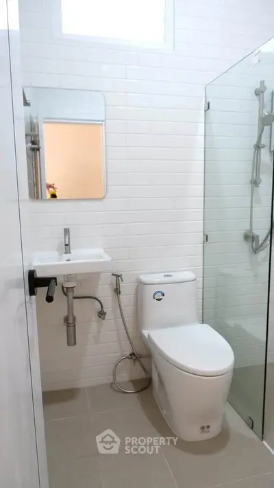 Modern bathroom with glass shower and sleek fixtures in a contemporary home.