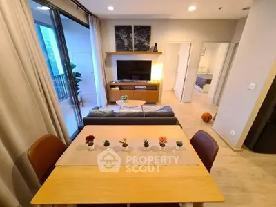 Modern living room with open layout and balcony access, featuring stylish decor and cozy ambiance.