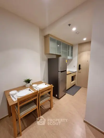 Modern kitchen with dining area and stainless steel fridge in cozy apartment