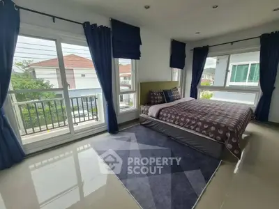 Spacious bedroom with large windows and modern decor in a stylish home.