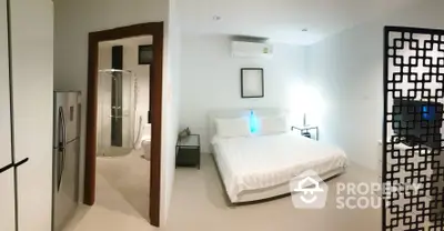 Spacious bedroom with modern design, featuring a large bed, sleek side tables, and an en-suite bathroom with glass shower enclosure.