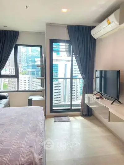 Modern bedroom with city view, large windows, and sleek furnishings in a high-rise apartment.