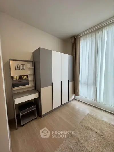 Modern bedroom with sleek wardrobe and vanity, featuring floor-to-ceiling curtains and wooden flooring.