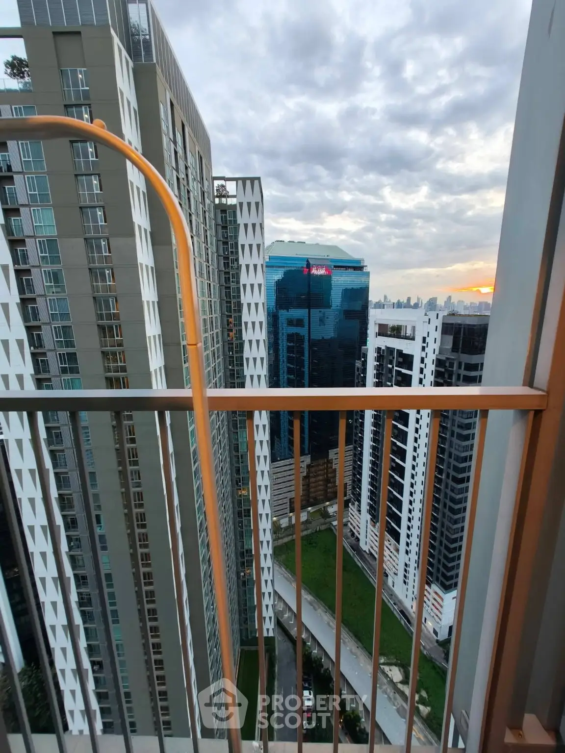 Stunning high-rise balcony view showcasing modern cityscape and architectural elegance at sunset.