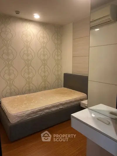 Cozy bedroom with modern design and air conditioning, featuring a comfortable bed and stylish wallpaper.