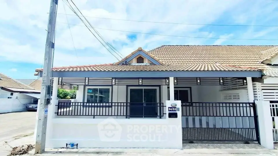Charming single-story home with tiled roof and gated front yard in a serene neighborhood.