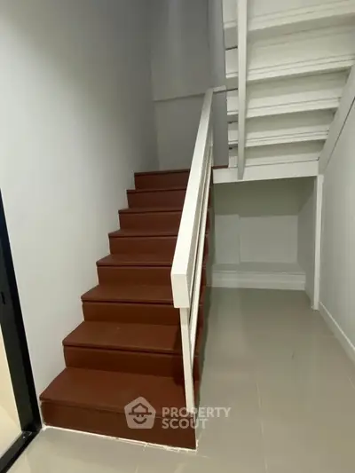 Modern staircase with sleek design and white railing in a contemporary home.
