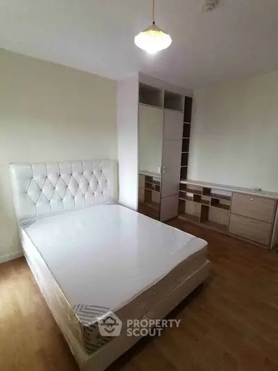 Spacious bedroom with modern furniture and ample storage in a stylish apartment.