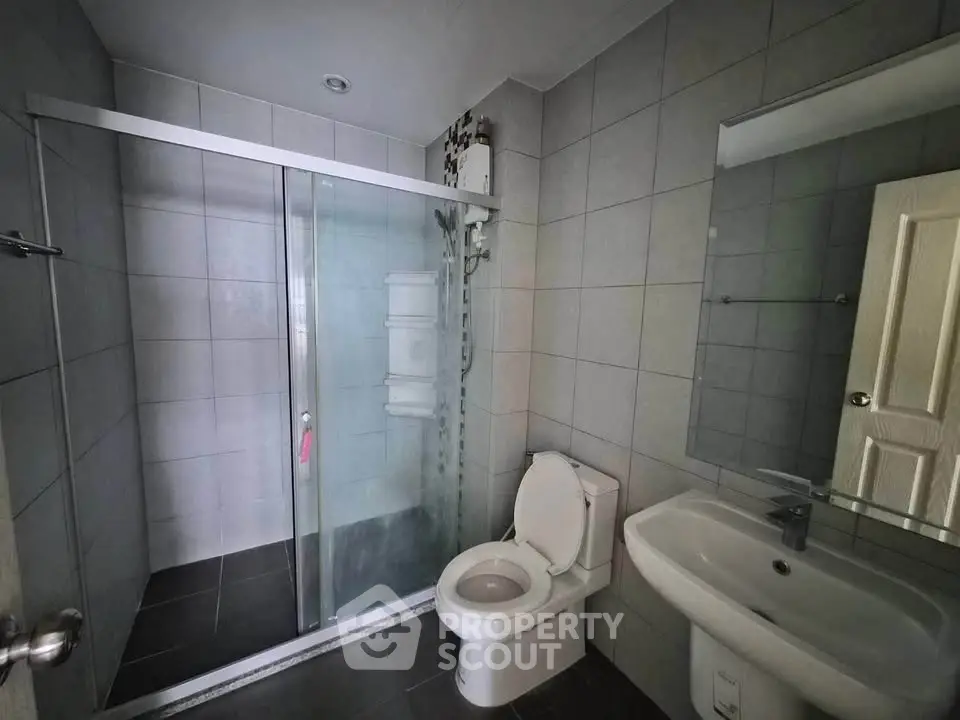 Modern bathroom with glass shower enclosure and sleek fixtures.