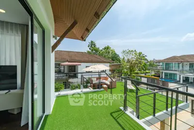 Luxurious balcony with artificial grass overlooking modern villas and lush greenery.