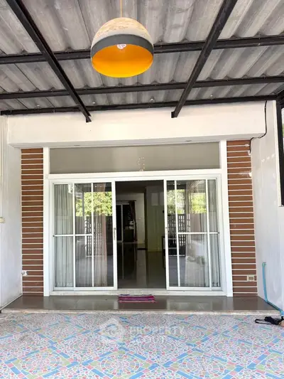 Charming covered patio with sliding glass doors and decorative tile flooring