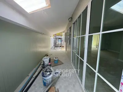 Spacious corridor with skylights and sliding glass doors in modern property.