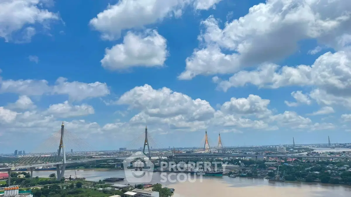 Stunning cityscape view with iconic bridge and river under a vibrant blue sky.