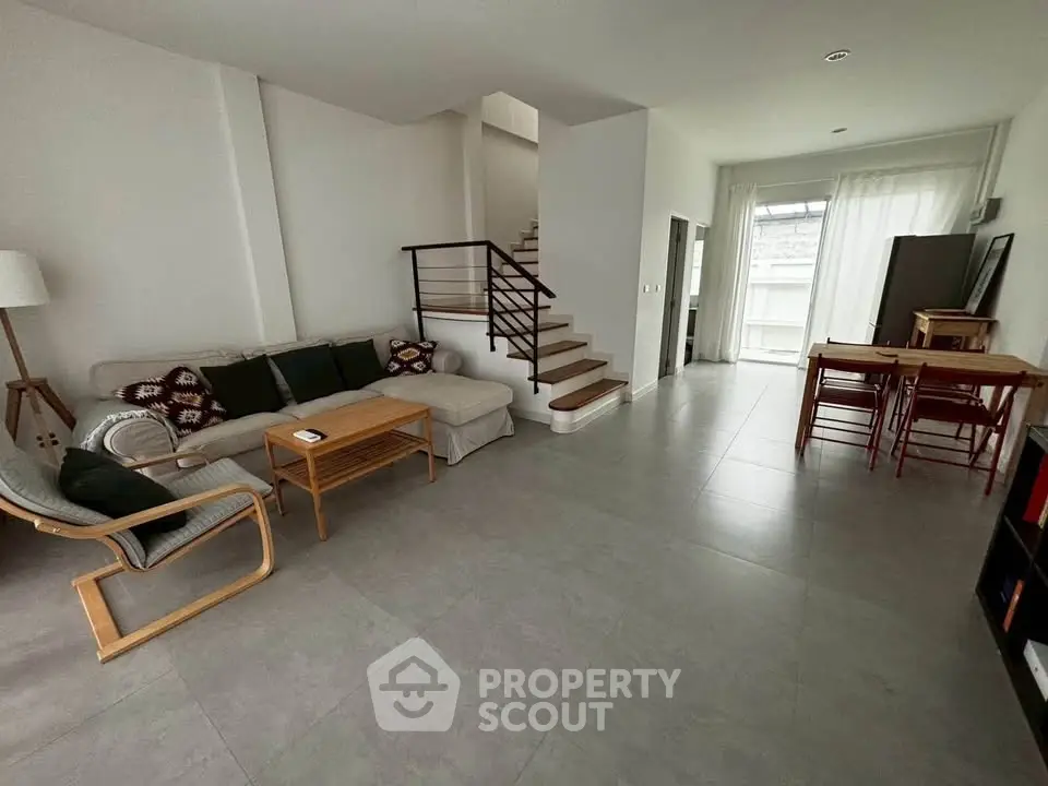 Spacious modern living room with cozy seating and natural light, perfect for relaxation and entertainment.