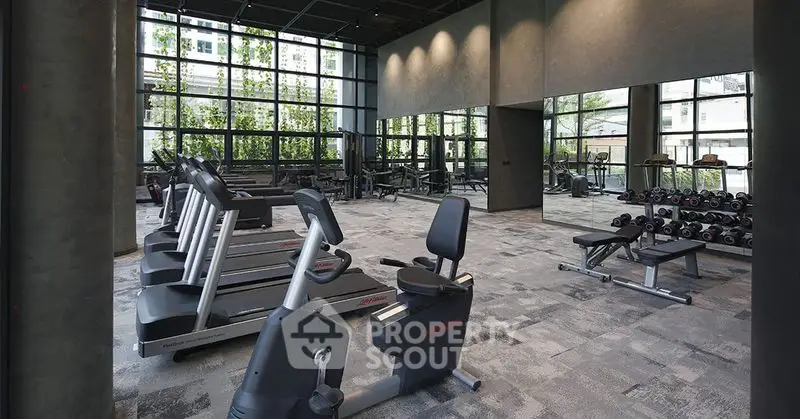 Modern gym with state-of-the-art equipment and floor-to-ceiling windows.