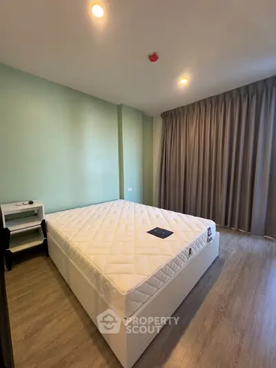 Spacious bedroom with modern decor and large window for natural light