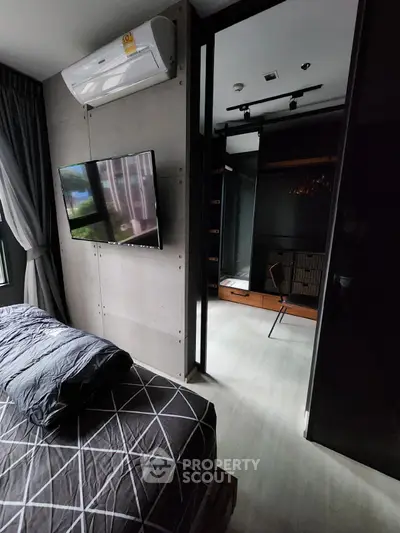 Modern bedroom with TV and air conditioning, leading to a stylish walk-in closet.