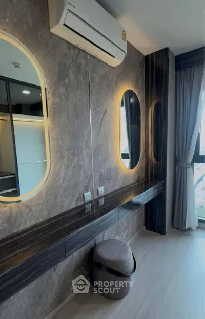 Modern bedroom with stylish mirrors and air conditioning, featuring elegant lighting and contemporary decor.