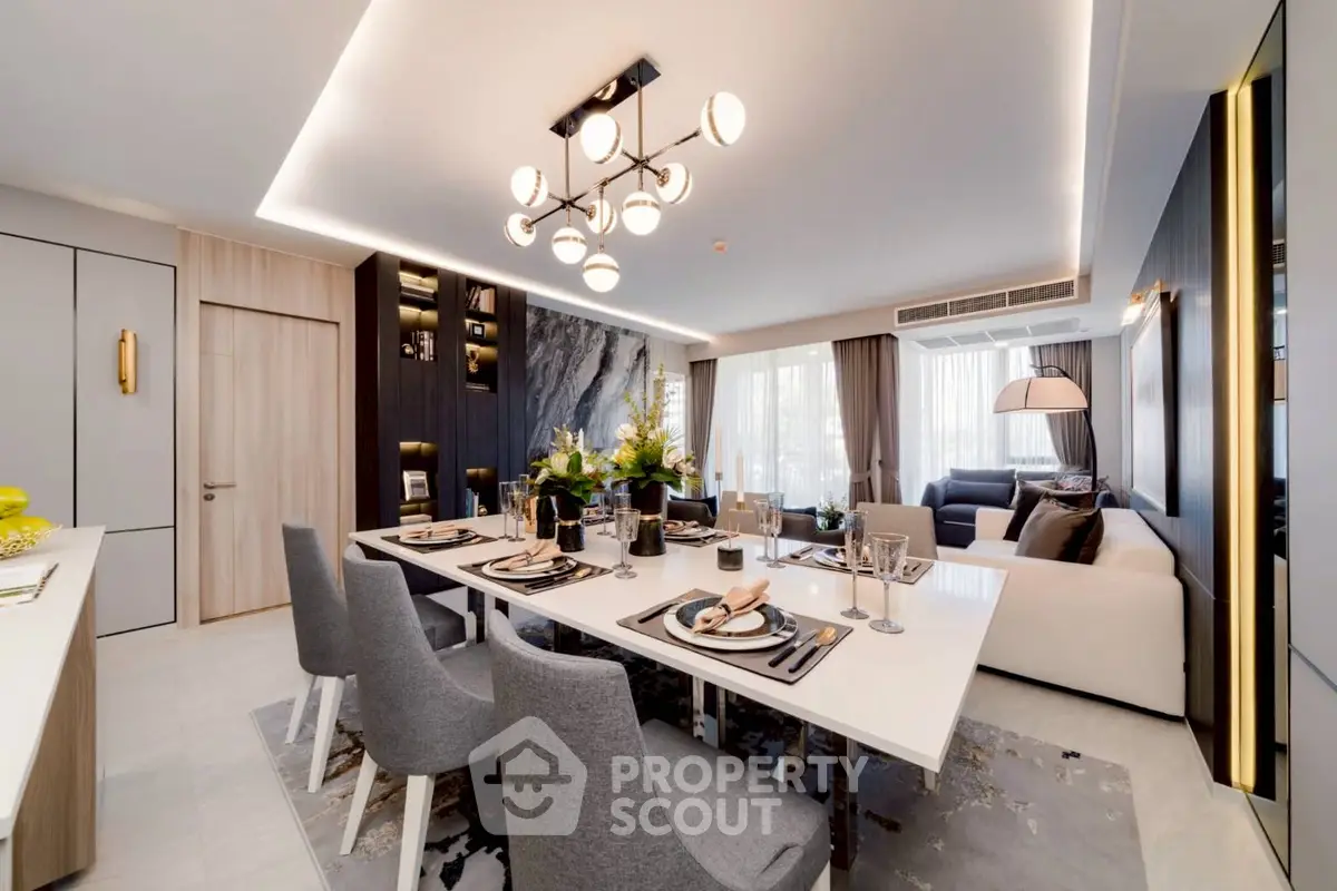 Luxurious open-plan living and dining area with modern decor and elegant lighting.