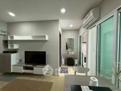 Modern living room with sleek design and open layout, featuring a TV and stylish shelving.
