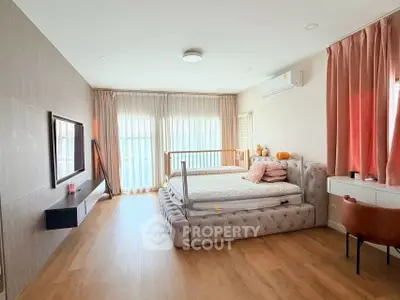 Spacious bedroom with elegant decor and large windows for natural light.