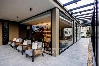 Luxurious modern balcony with stylish seating and glass walls offering stunning views.