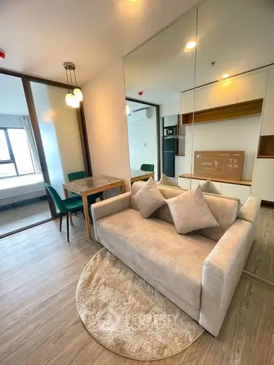 Modern living room with cozy sofa, dining area, and mirrored wall in a stylish apartment.