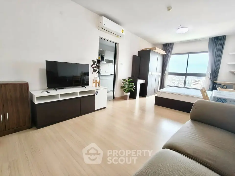 Spacious modern studio apartment with open layout and large window view.