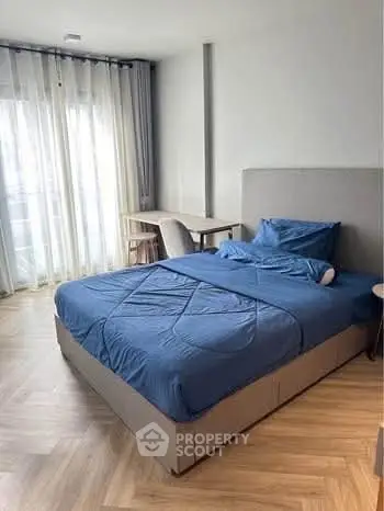 Spacious bedroom with modern decor and natural light, featuring a comfortable bed and stylish furnishings.