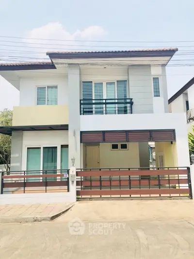 Modern two-story house with balcony and spacious driveway