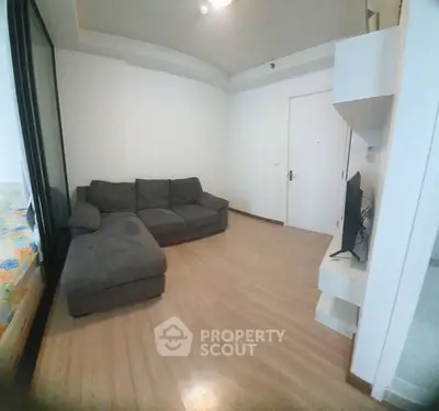 Cozy living room with modern sofa and wall-mounted TV in a stylish apartment.