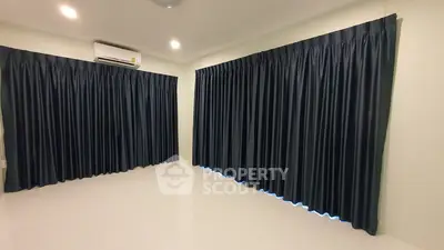 Spacious room with dark curtains and air conditioning, ideal for customization.
