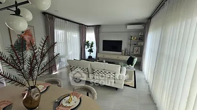 Elegant living room with modern decor and large windows, featuring a cozy seating area and stylish dining setup.