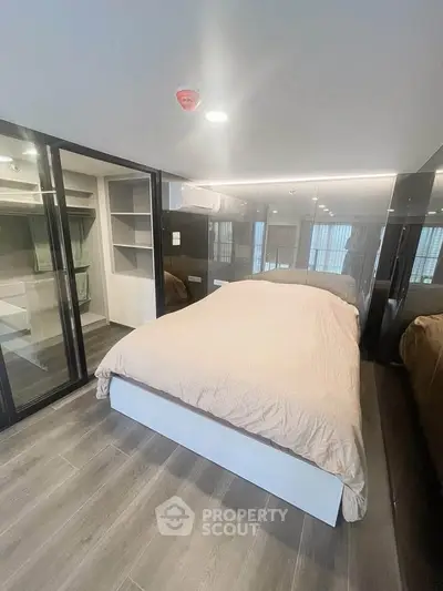 Modern bedroom with sleek glass walls and cozy bed in stylish apartment